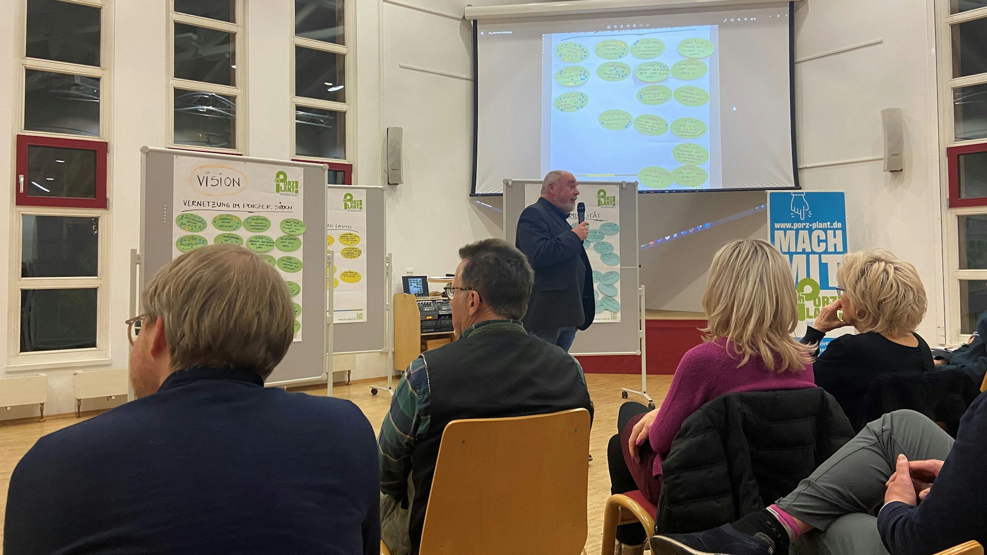 Ein Mann am Mikrofon hält einen Vortrag.