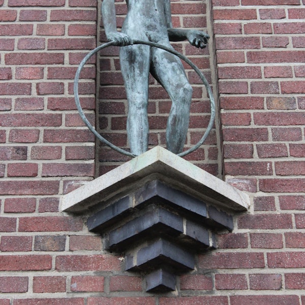 Das Bild zeigt die Skulptur eines Mädchens, das einen Reifen in der Hand hält.