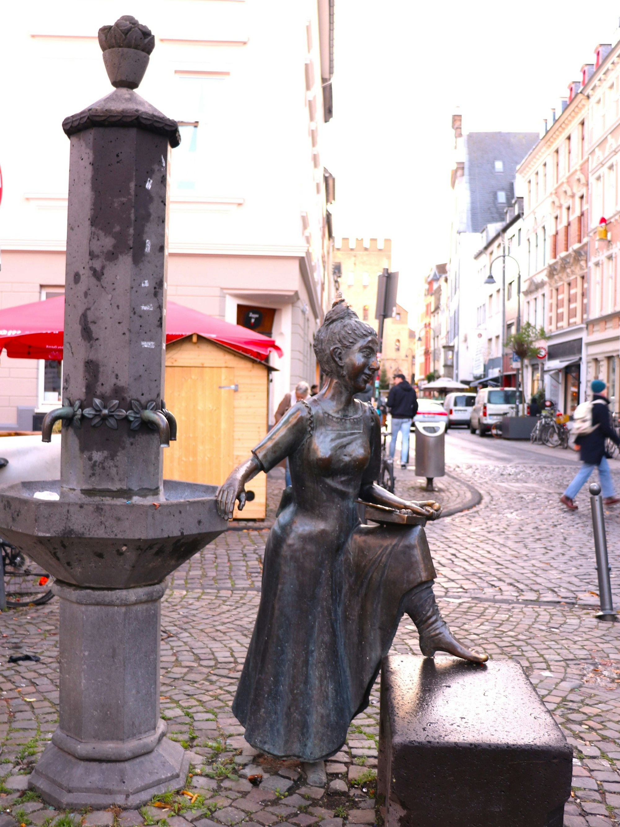 Ein Brunnen in Säulenform mit einer Frauenfigur