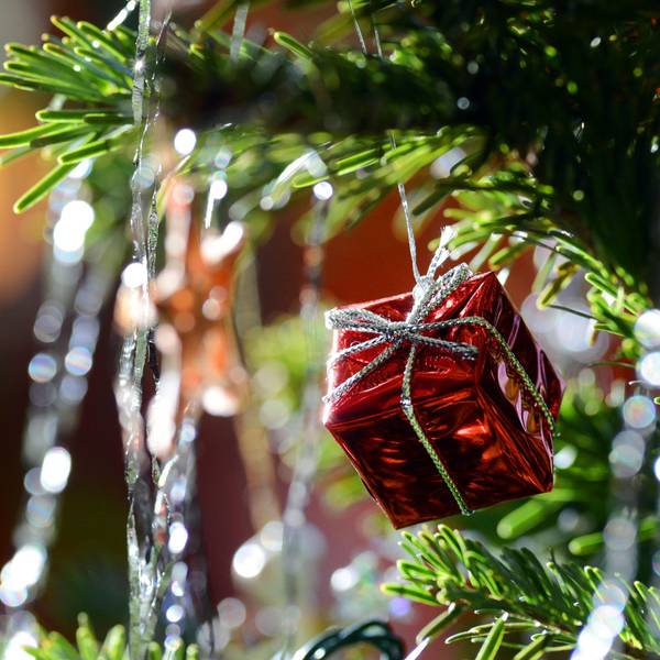 Ein kleines rotes Geschenkpaket als Weihnachtsbaumanhänger und Lametta hängen am 30.12.2012 an einem Weihnachtsbaum.