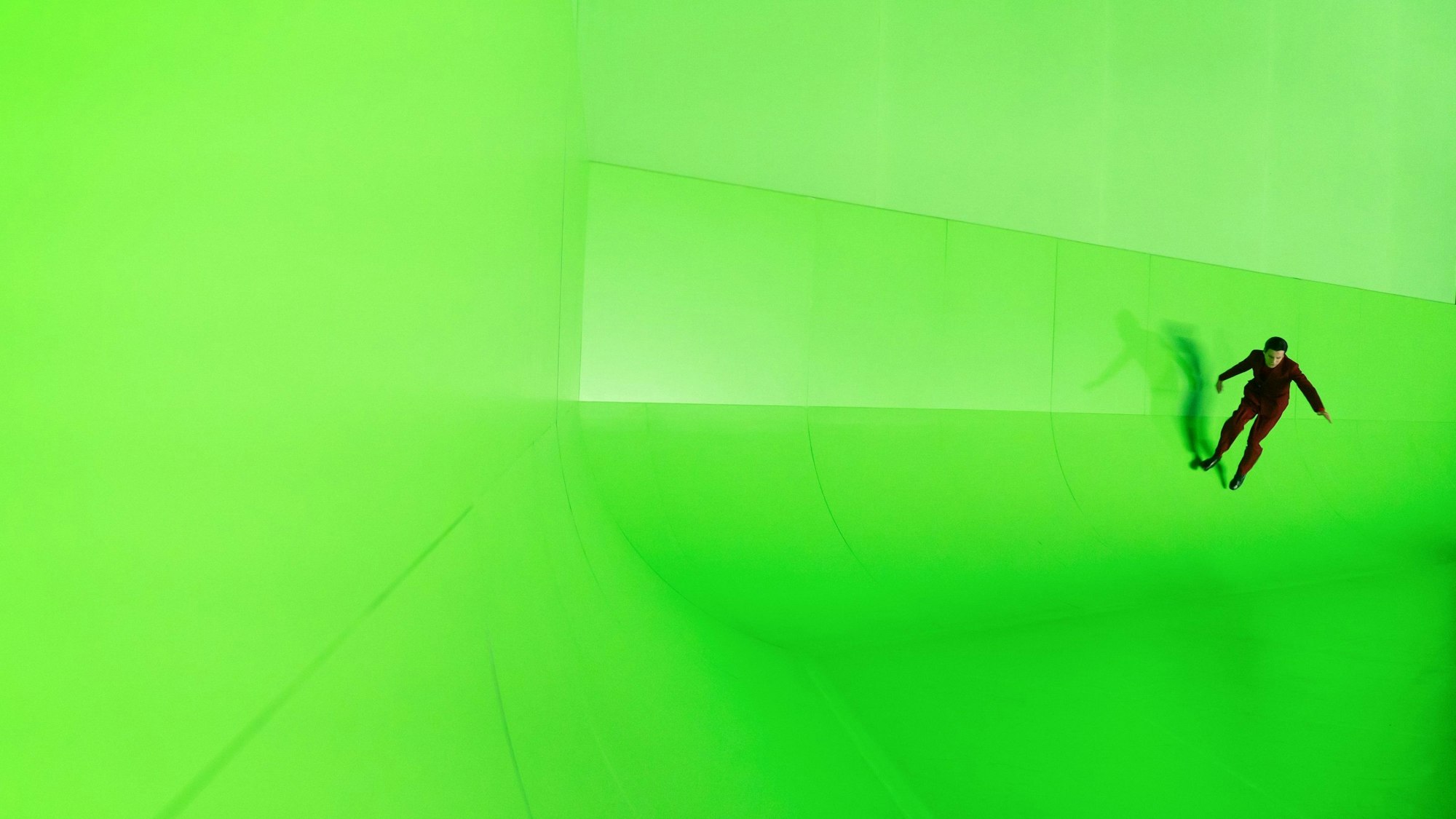 „Der Prozess“ von Franz Kafka, Regie: Pınar Karabulut, zu sehen ist Bekim Latifi, der eine riesige Greenscreen-Wand hochläuft