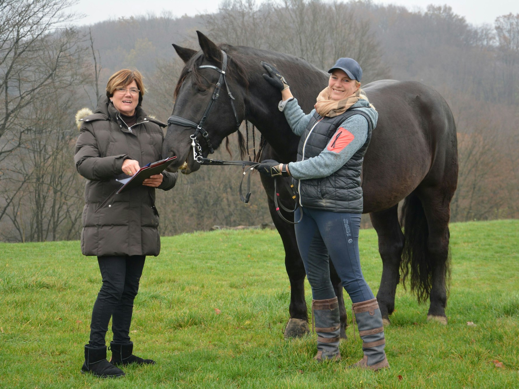 Zwei Frauen mit einem schwarzen Pferd
