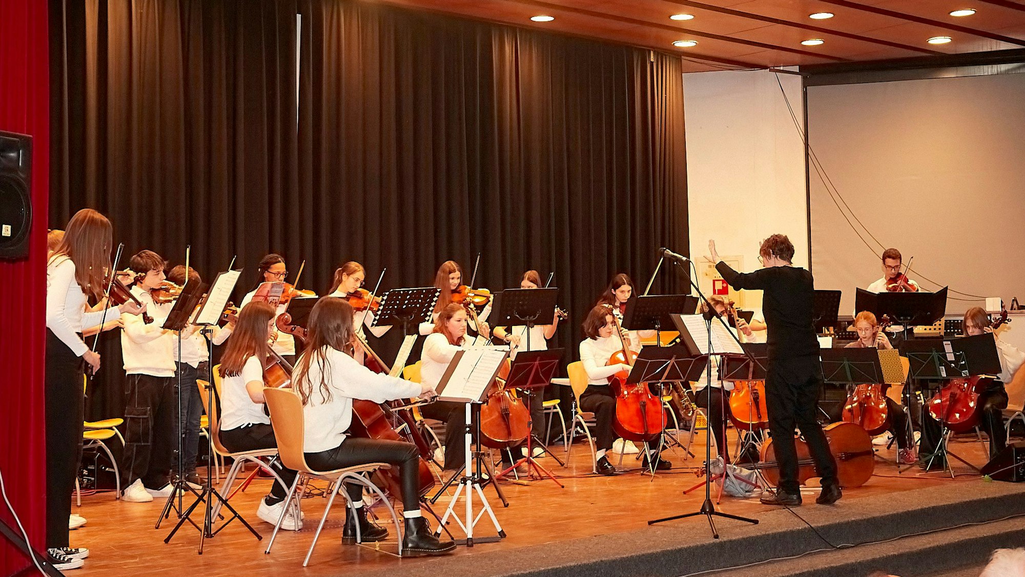 Das Bild zeigt das Schüler-Streichorchester der Musikschule Schleiden, das von Astrid Erdmann-Holder geleitet wird, auf der Bühne beim Unicef-Konzert.