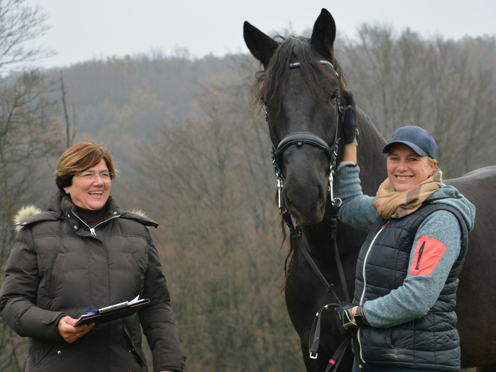 Zwei Frauen mit einem schwarzen Pferd