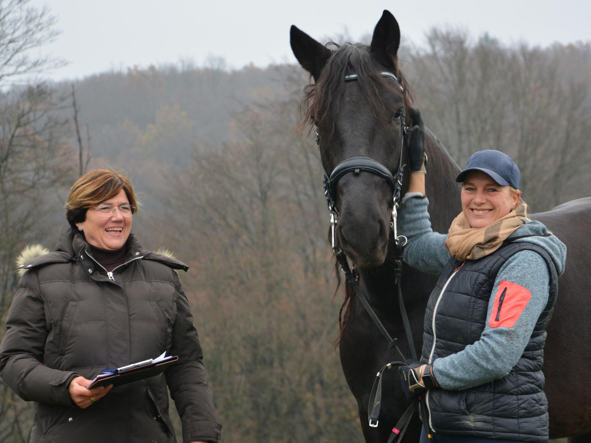Zwei Frauen mit einem schwarzen Pferd