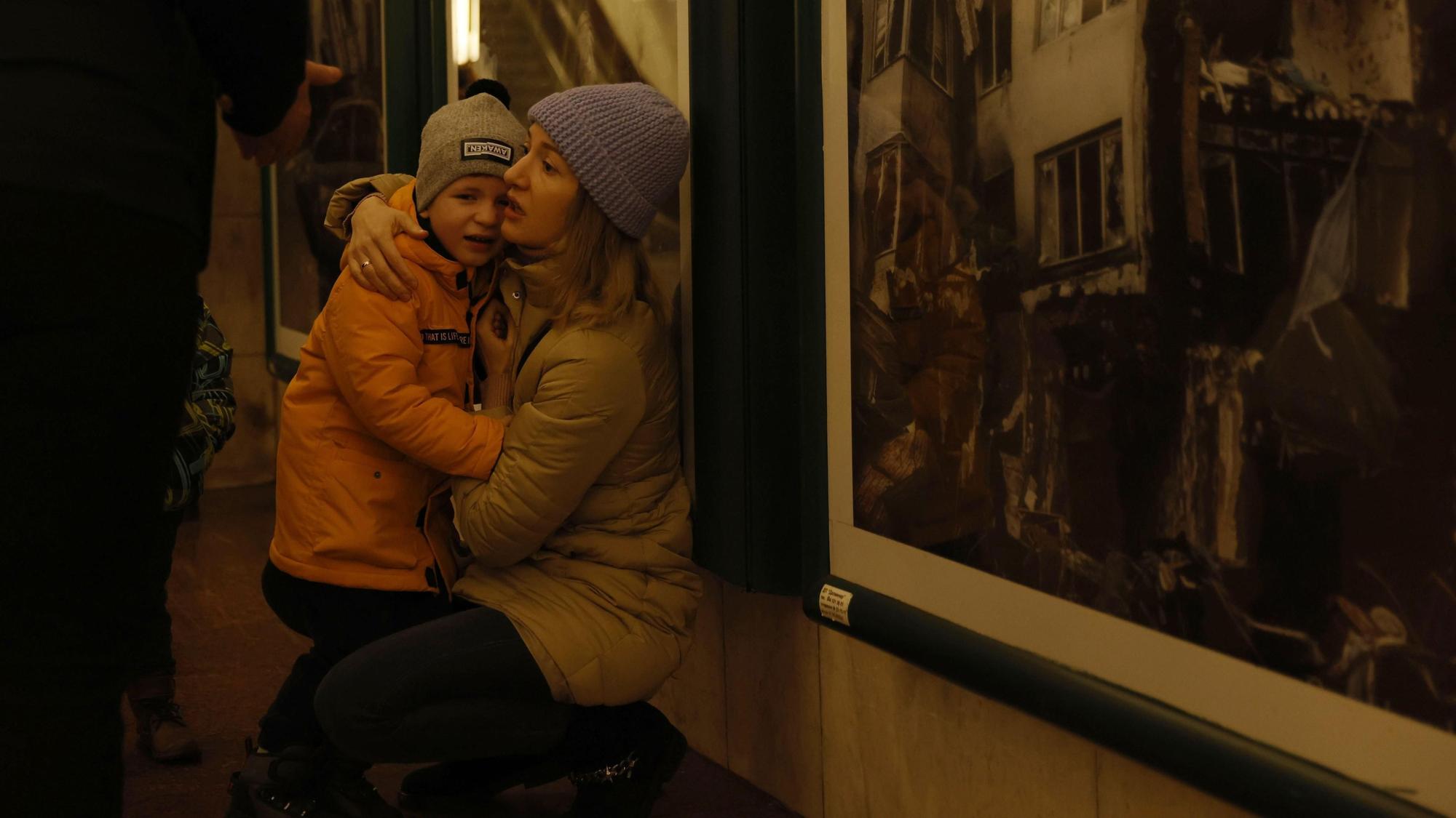Eine Mutter tröstet ihr Kind während Menschen an Silvester Schutz in einer U-Bahn-Station suchen. Kurz vor und auch nach dem Jahreswechsel haben russische Drohnen erneut das Land angegriffen. Im Süden und Osten der Ukraine, sowie in Kiew wurde Luftalarm ausgelöst. +++ dpa-Bildfunk +++