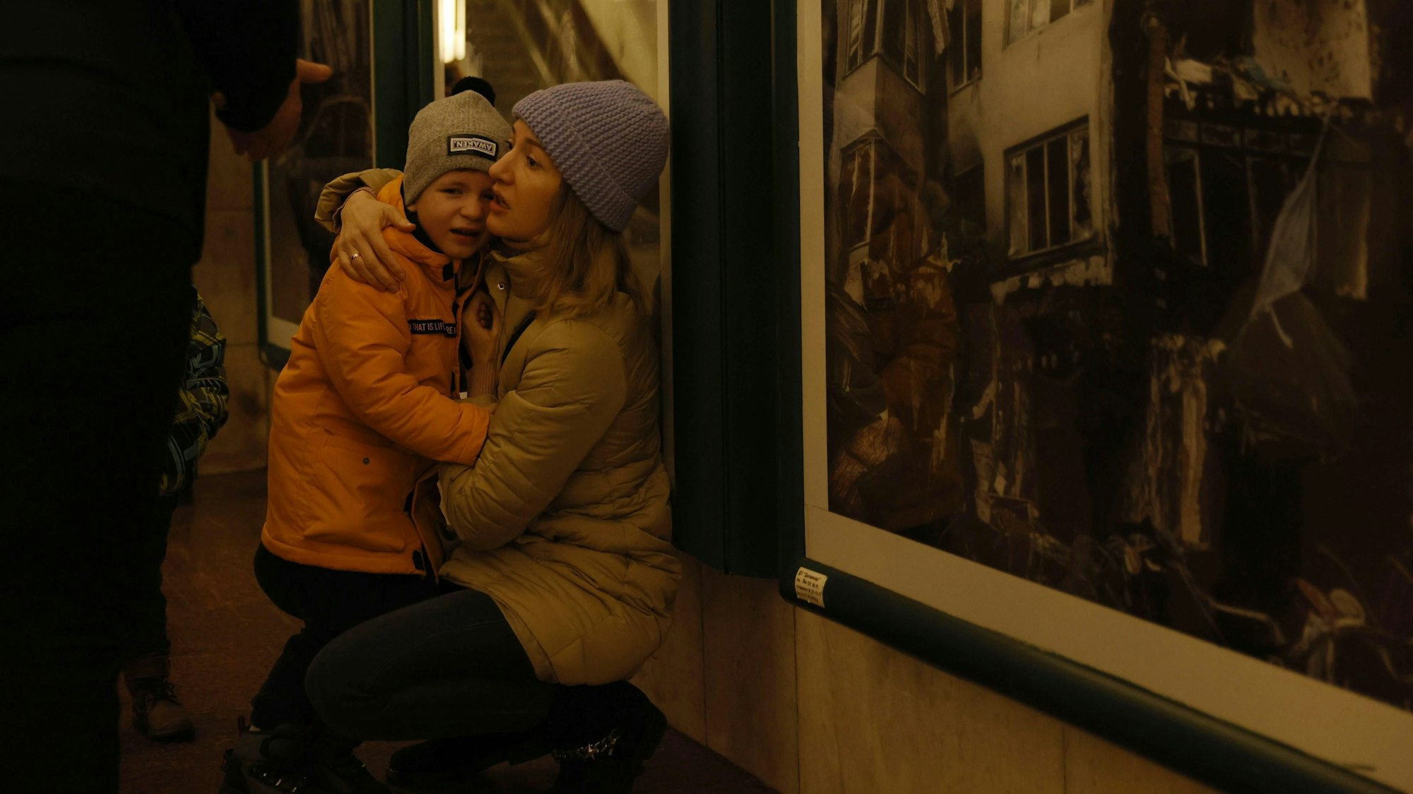 Eine Mutter tröstet ihr Kind während Menschen an Silvester Schutz in einer U-Bahn-Station suchen. Kurz vor und auch nach dem Jahreswechsel haben russische Drohnen erneut das Land angegriffen. Im Süden und Osten der Ukraine, sowie in Kiew wurde Luftalarm ausgelöst. +++ dpa-Bildfunk +++
