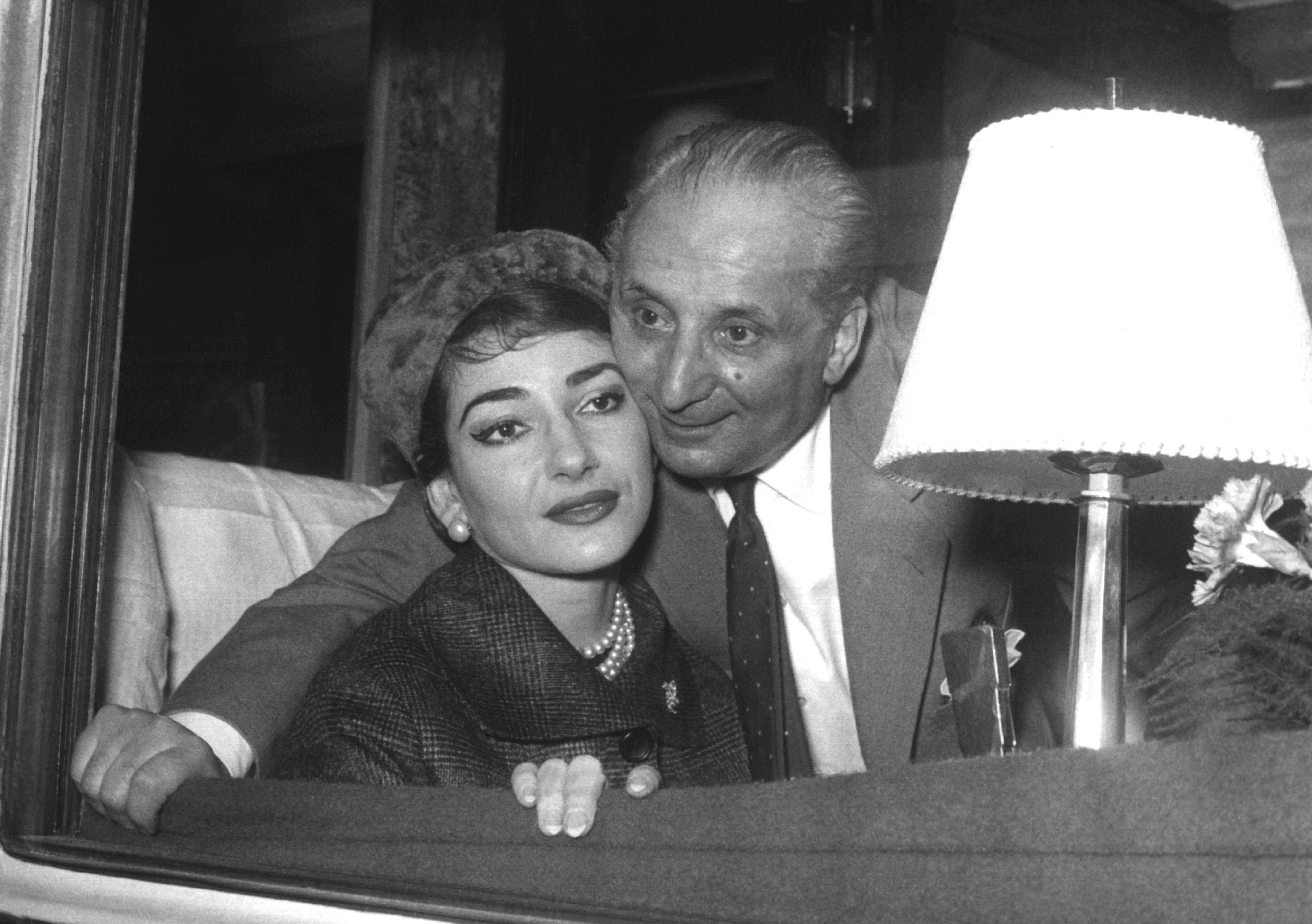 Maria Callas und ihr Ehemann schauen aus einem Zugfenster.