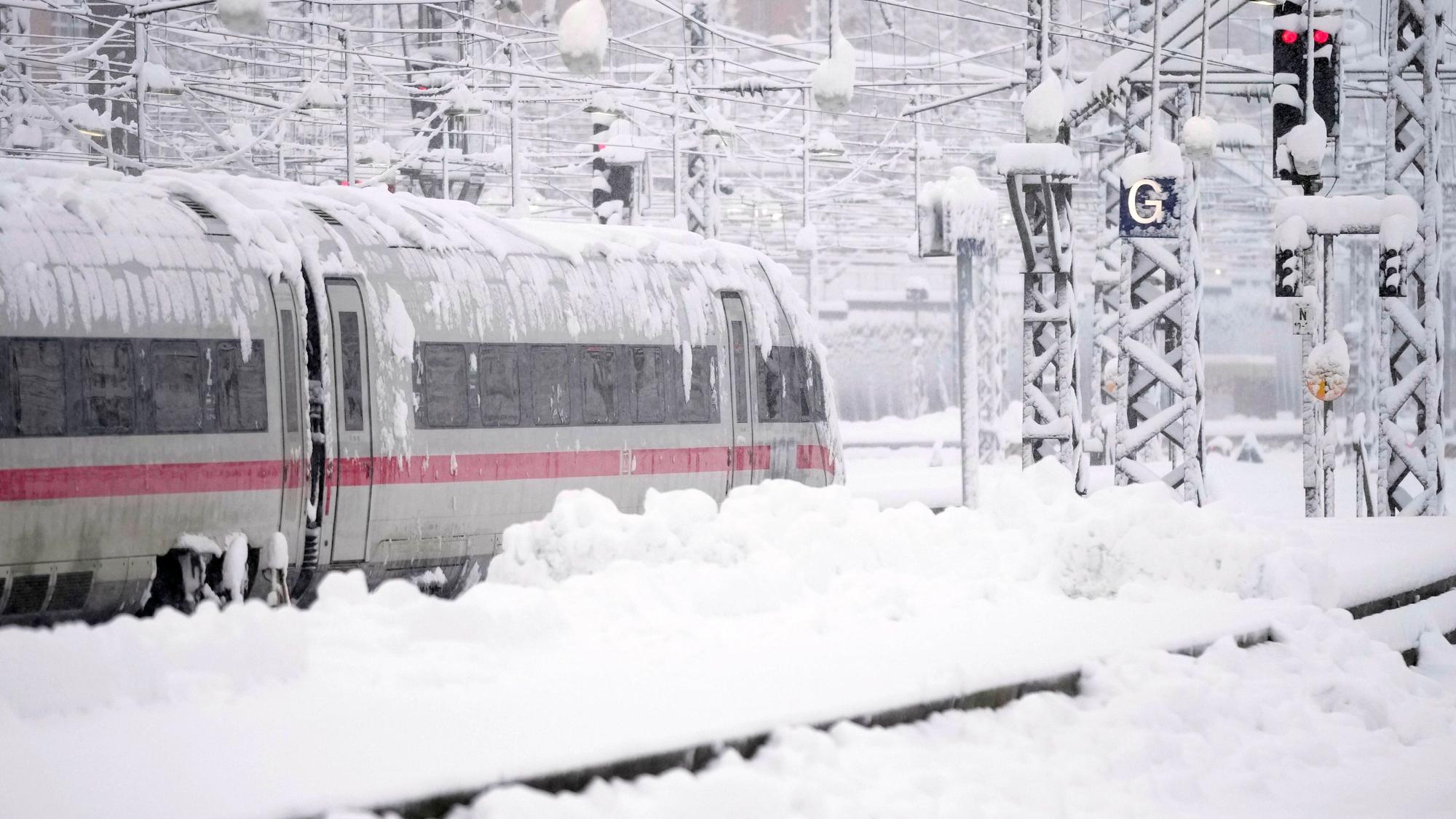 02.12.2023, Bayern, München: Ein ICE steht nach starkem Schneefall am Hauptbahnhof. Schnee und Eis haben im Süden Bayerns auf den Straßen und bei der Bahn für Chaos gesorgt. Foto: Matthias Schrader/AP/dpa +++ dpa-Bildfunk +++