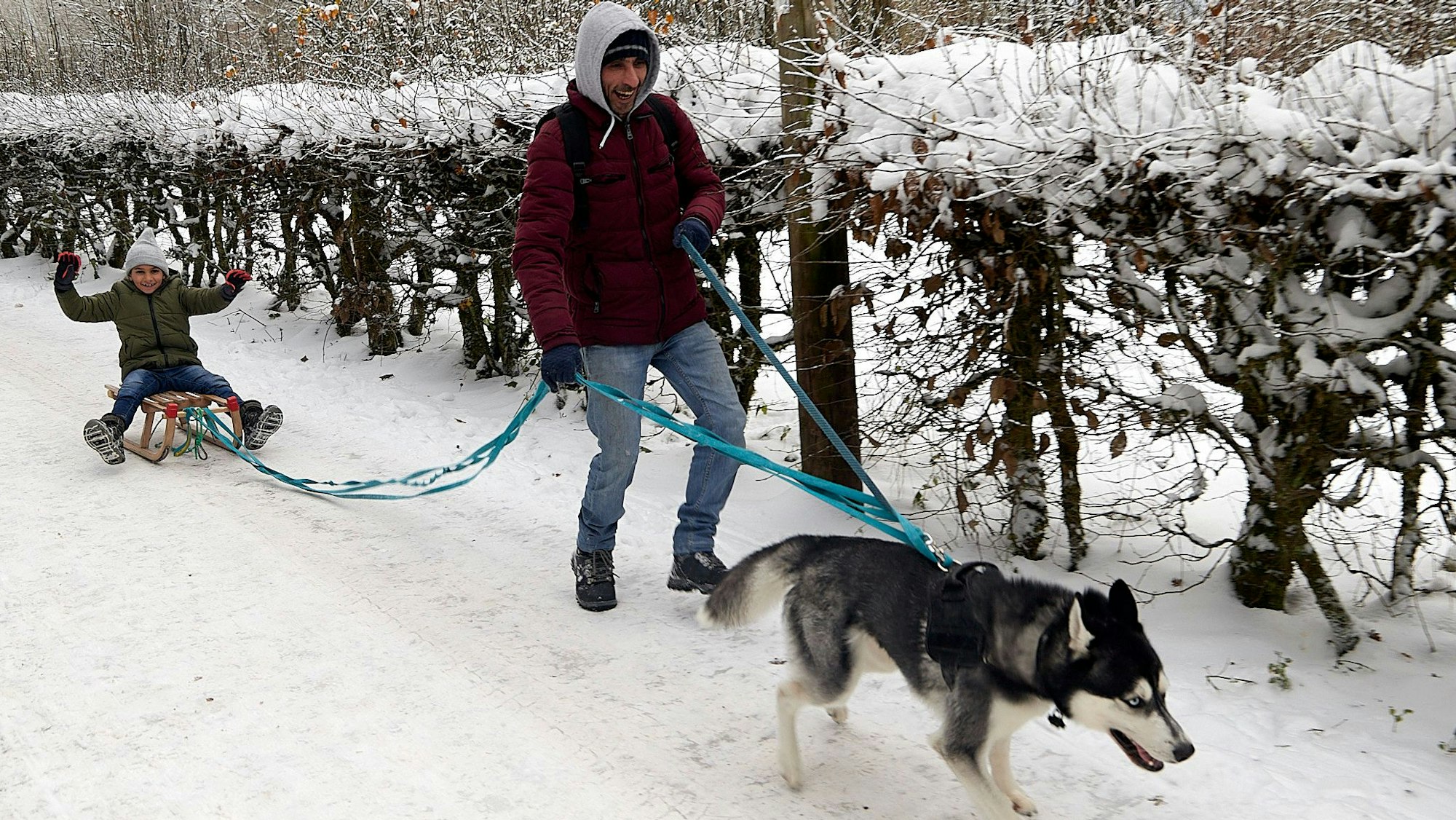 Vorne zieht der Hund an der Leine, dahinter Ulas Demirtepe, der seinen Sohn auf einem Schlitten hinter sich herzieht.