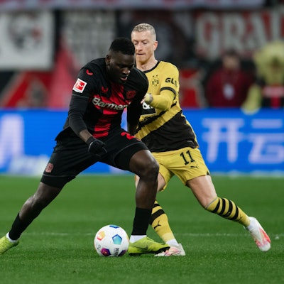 Leverkusens Victor Boniface (l) und Dortmunds Marco Reus kämpfen um den Ball.