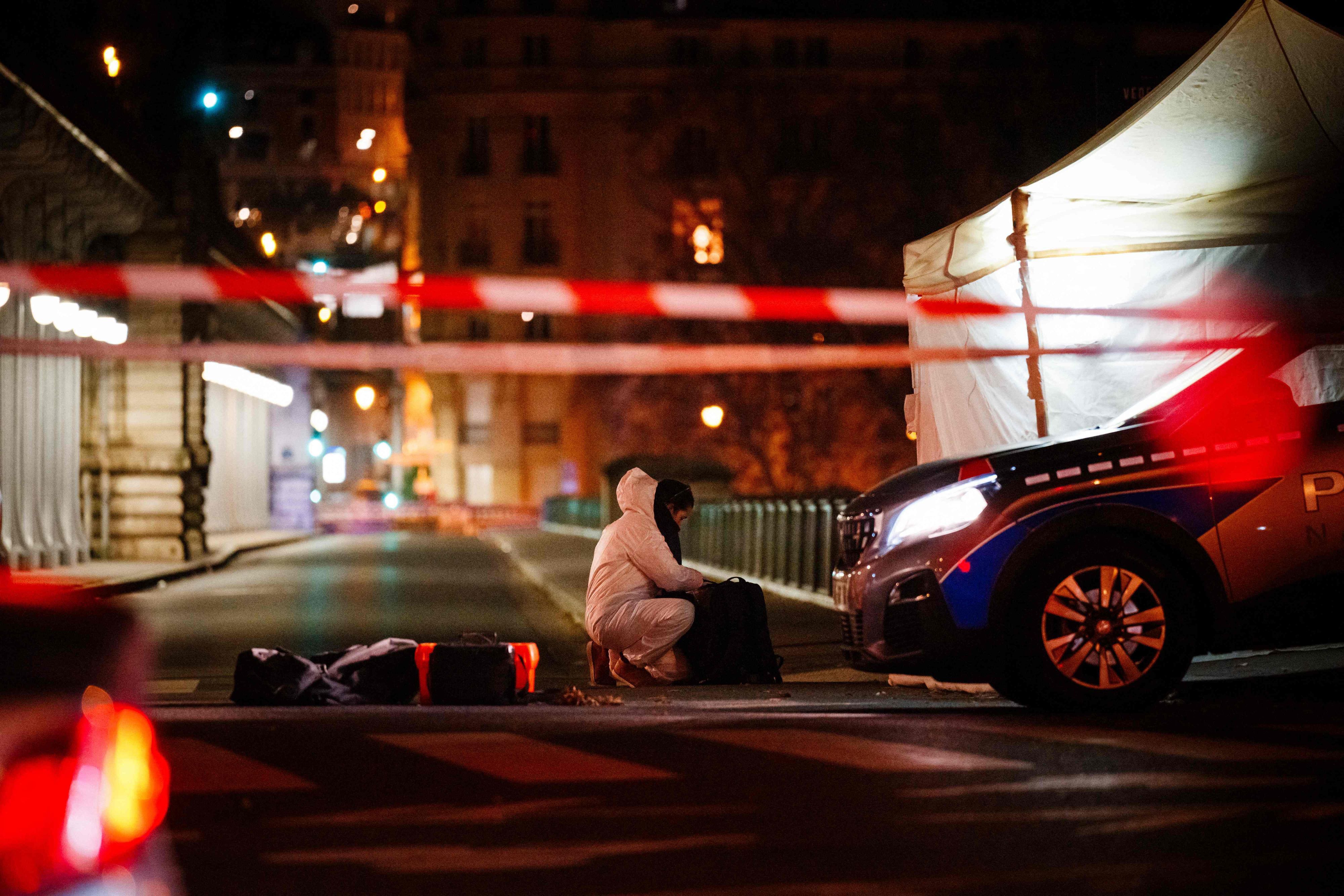 Ein Beamter der Kriminalpolizei arbeitet am Tatort in Paris. Ein mutmaßlicher Islamist hat unweit des Eiffelturms am Samstagabend einen deutschen Touristen mit einem Messer getötet. Zwei weitere Menschen seien verletzt worden, einer davon mit einem Hammer.