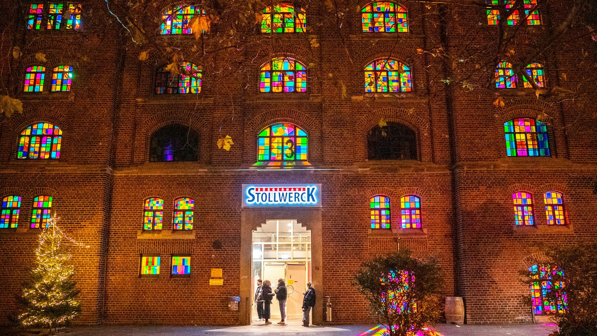Front des Kölner Stollwercks mit bunt beleuchteten Fenstern