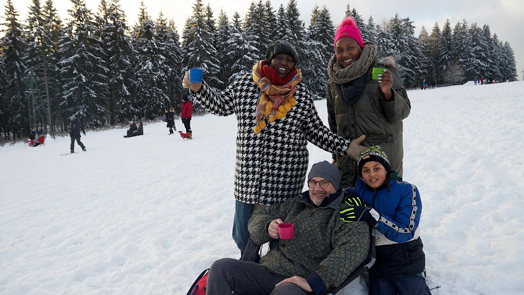 Die Familie genießt die Idylle auf dem Rodelhang.