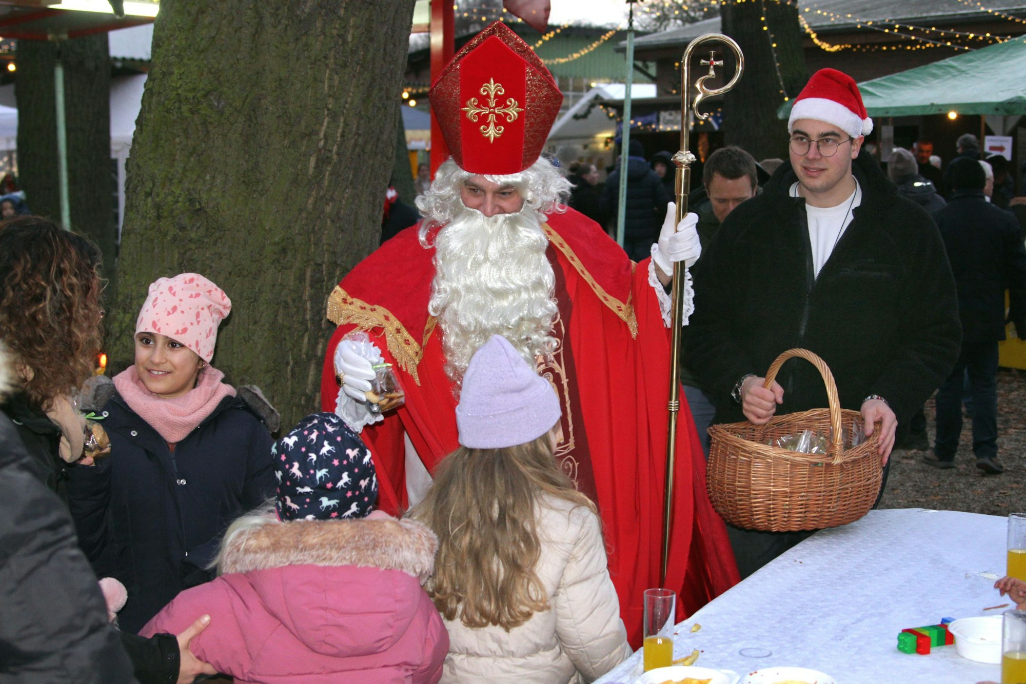 Ein Nikolaus im roten Mantel verteilt Süßigkeiten.