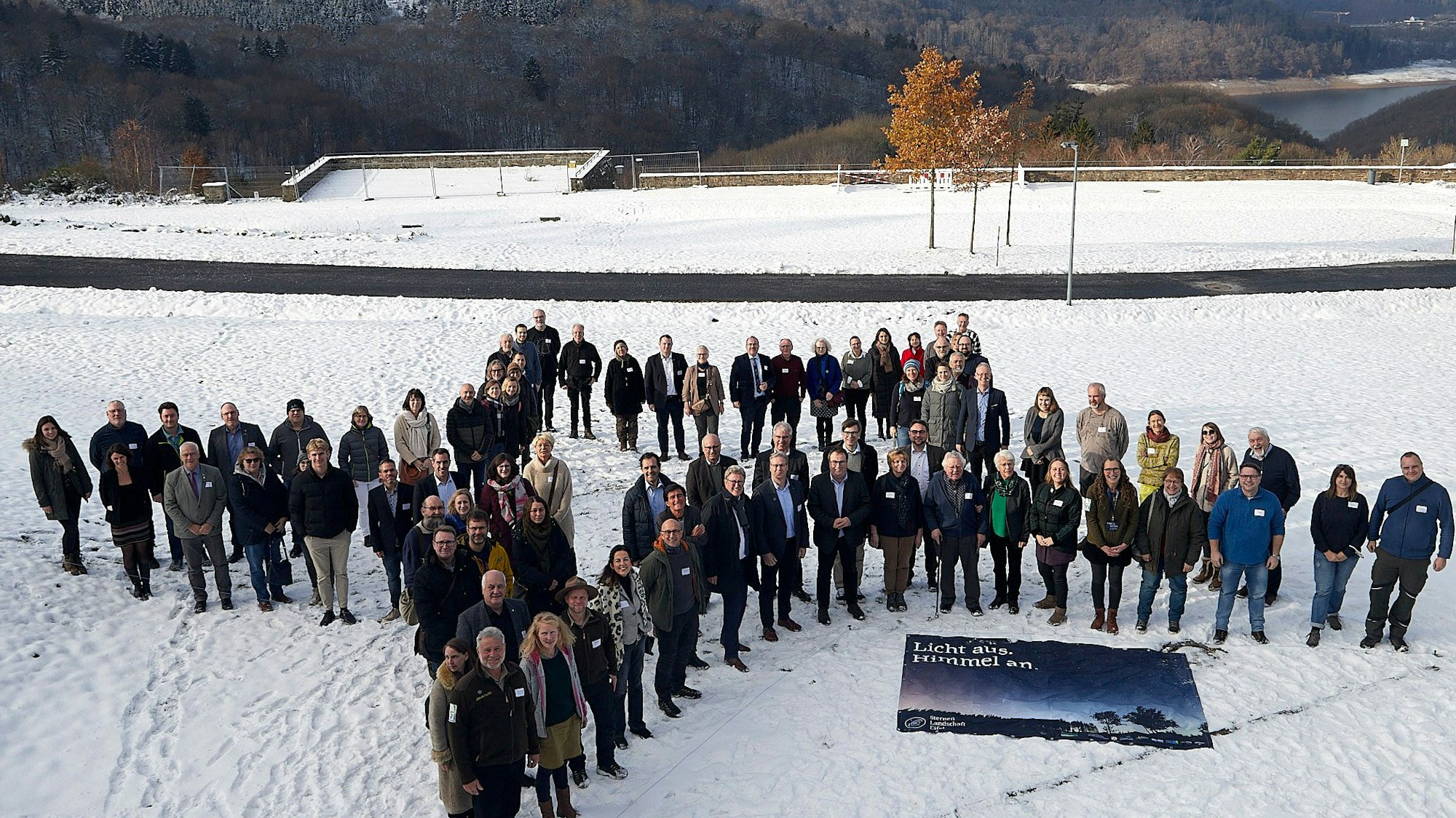 Die Gäste stehen in Sternform im Schnee.