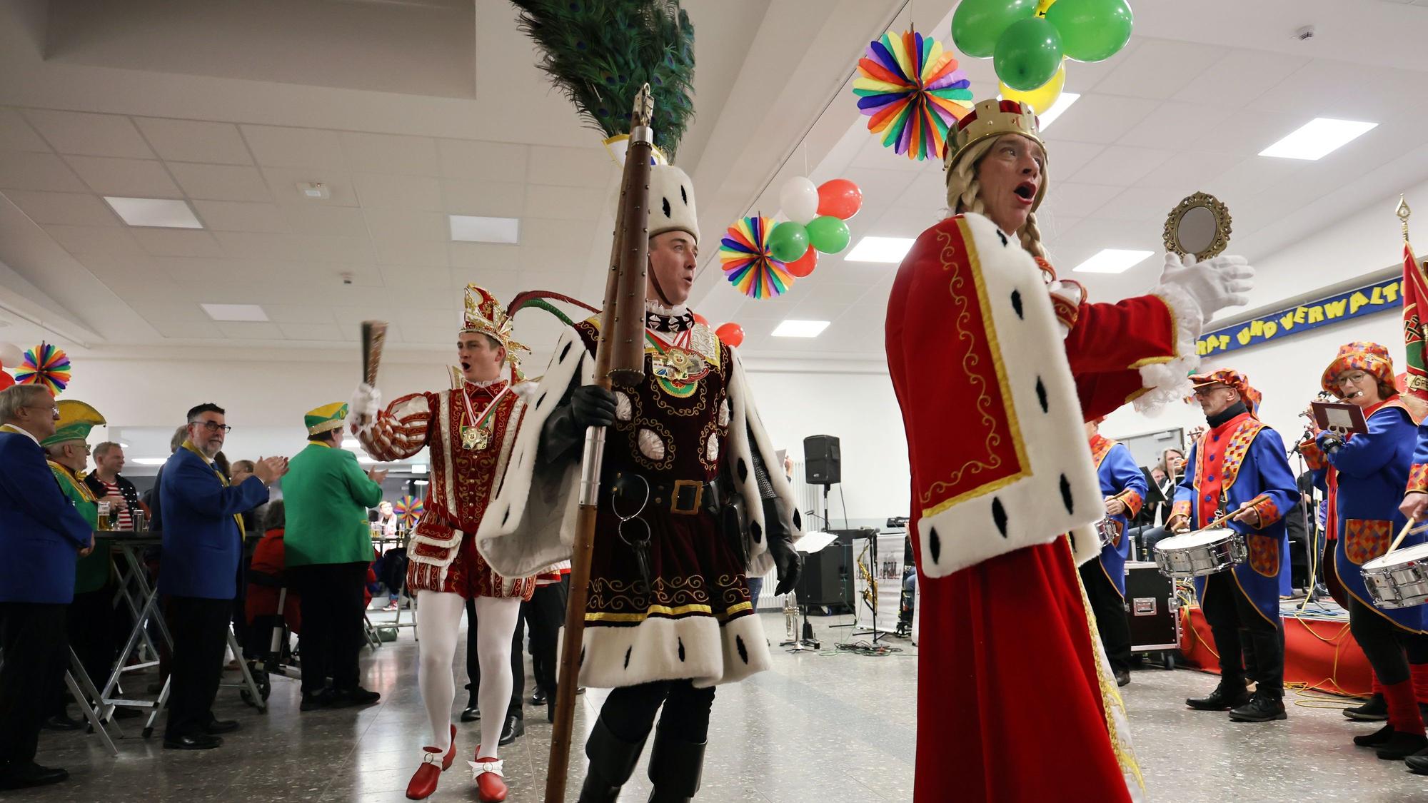 Zu den Klängen des Tambourcorps ziehen Jungfrau, Bauer und Prinz im Ornat in einer Reihe hintereinander in die Aula der Barbaraschule.