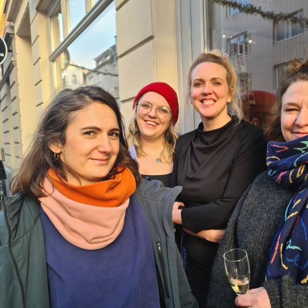 Vier Frauen stehen vor einer Ladenfront. Alles vier lachen selbstbewusst in die Kamera.