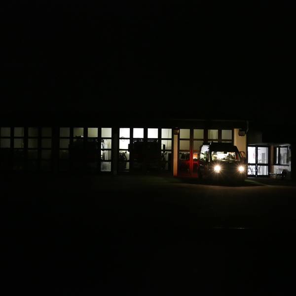 Ein Dieselgenerator spendet spärliches Licht im Feuerwehrhaus in Ruppichteroth, wo die Einsatzkräfte die Lage am Samstagabend genau im Blick haben. In mehreren Ortsteilen war stundenlang der Strom ausgefallen.