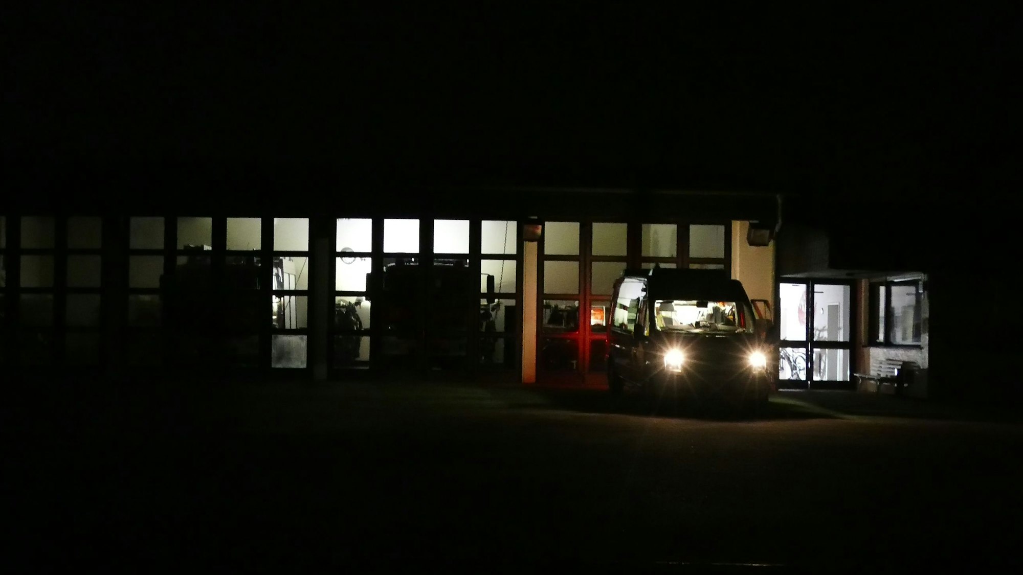 Ein Dieselgenerator spendet spärliches Licht im Feuerwehrhaus in Ruppichteroth, wo die Einsatzkräfte die Lage am Samstagabend genau im Blick haben. In mehreren Ortsteilen war stundenlang der Strom ausgefallen.