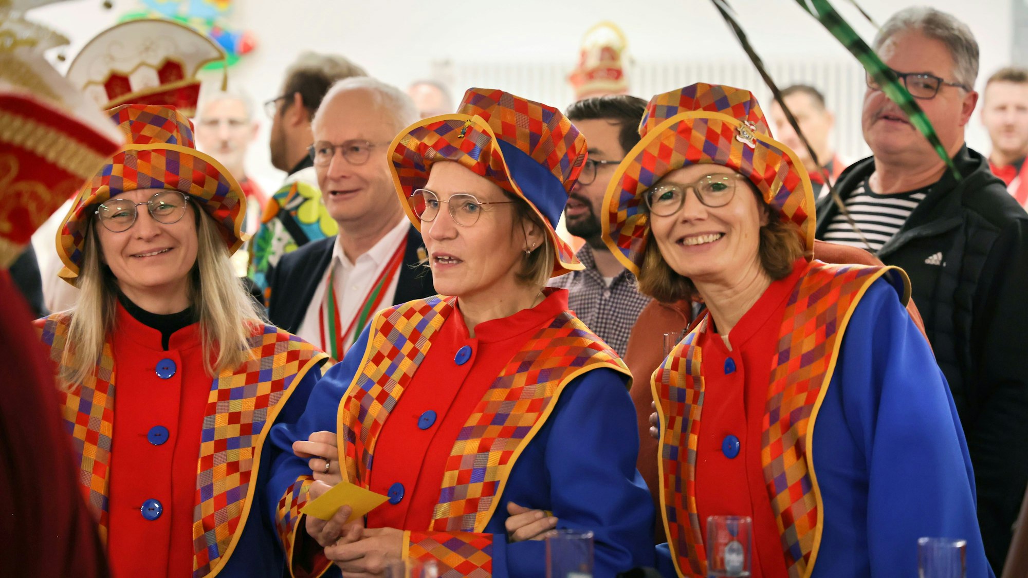 Drei kostümierte Musikerinnen haben sich eingehakt und schunkeln.