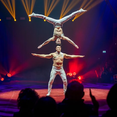 Das Duo Kvas balanciert Kopf-auf-Kopf auf der Bühne.