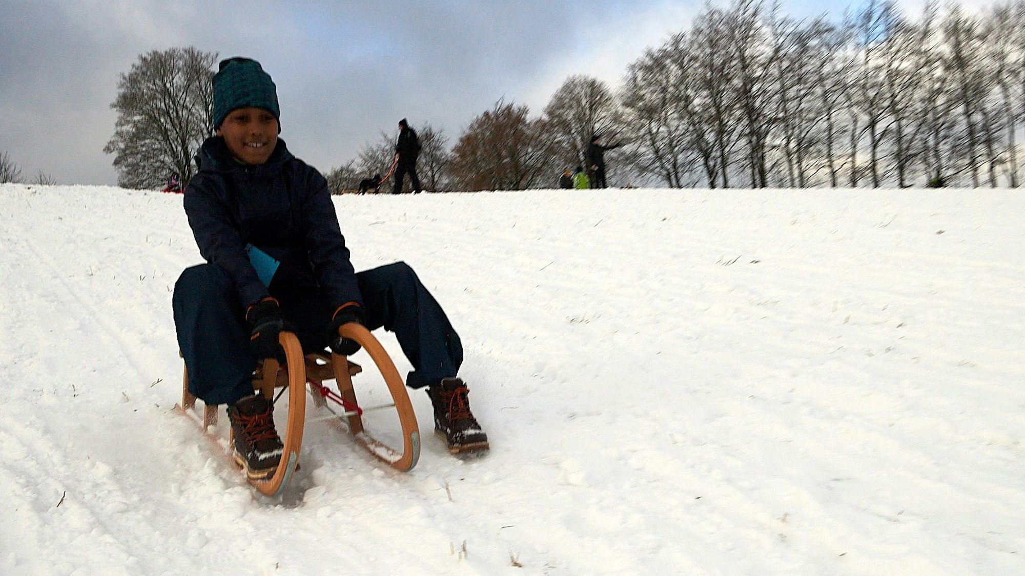 Ruben hat beim Rodeln den Hang fast allein für sich.