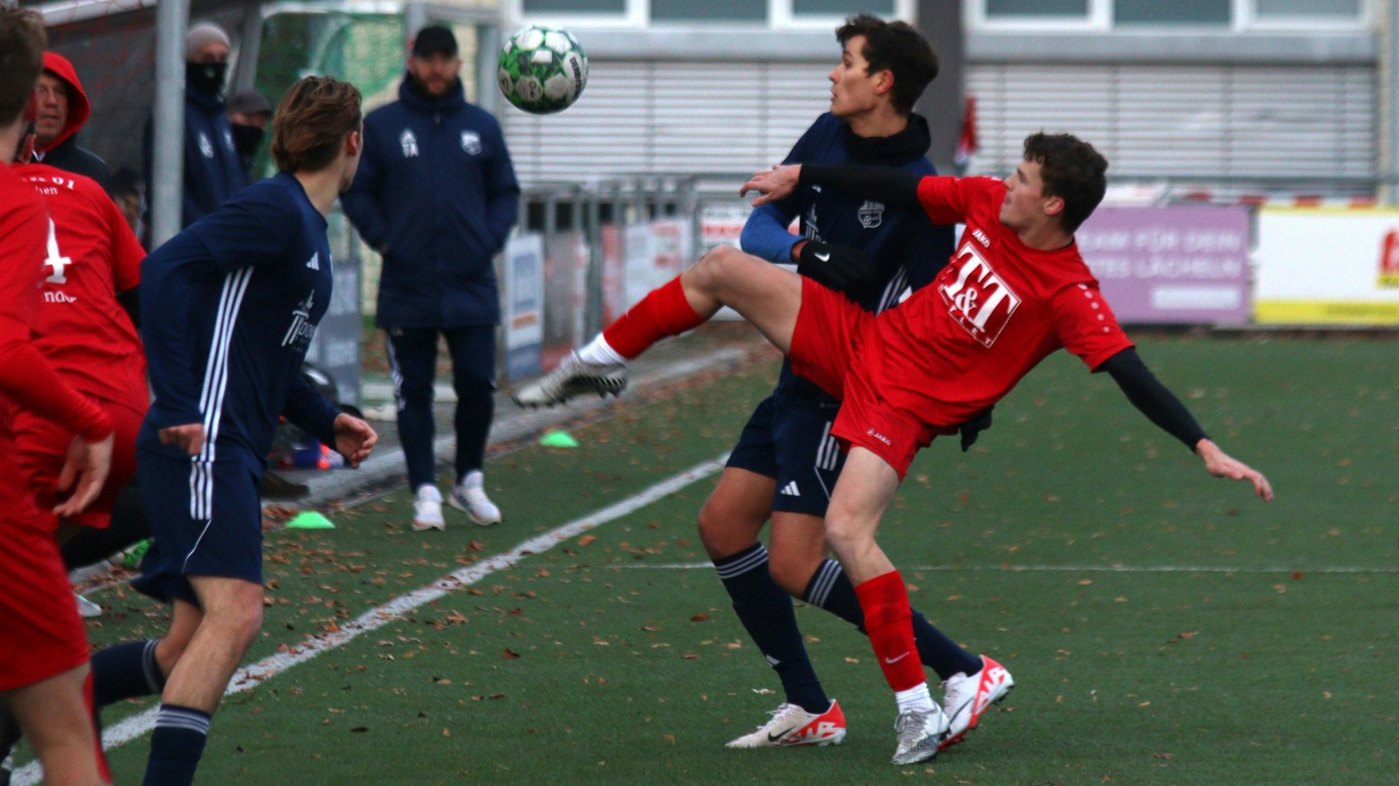 Erft-01-Spieler Leo Richerzhagen versucht den Ball, der in Kopfhöhe ist, mit dem Fuß zu erreichen.