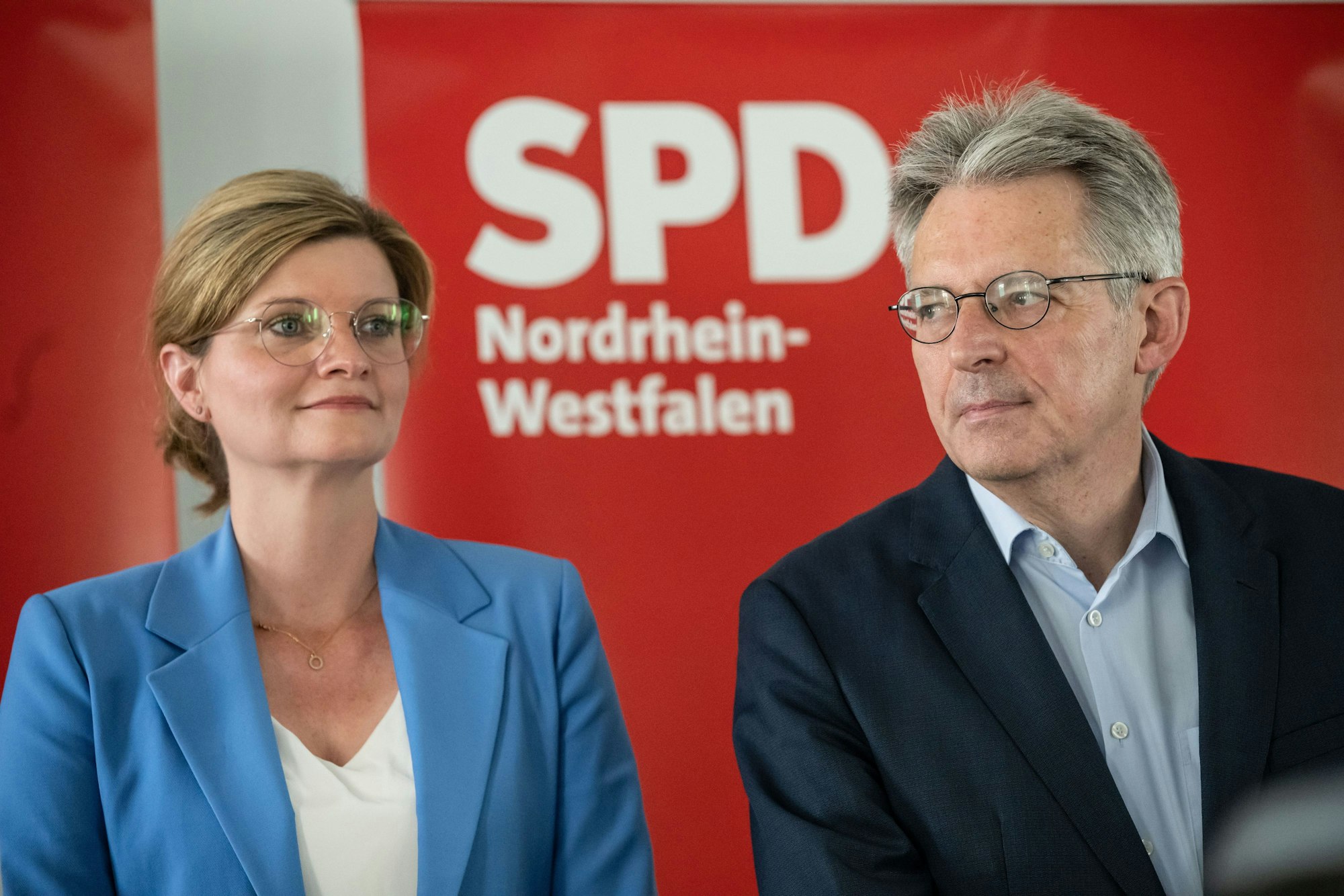 Sarah Philipp, Duisburger Landtagsabgeordnete, und Achim Post, Vorsitzender der nordrhein-westfälischen Landesgruppe im Bundestag, sind im Porträt vor einem SPD-Plakat zu sehen. Seit 100 Tagen führt das Tandem die nordrhein-westfälische SPD.