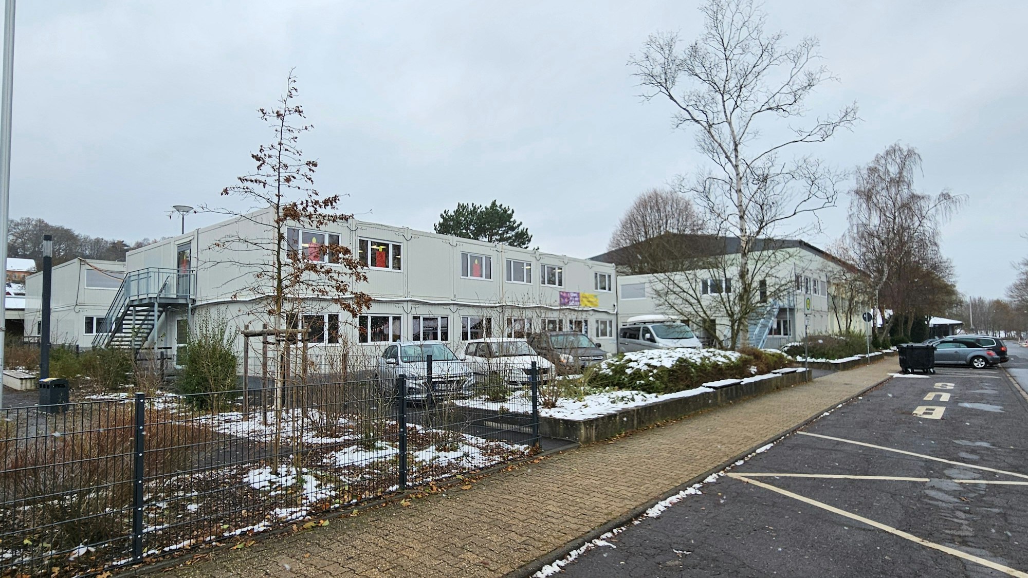 Blick auf die Container an der Kaller Grundschule und der Sporthalle im Hintergrund.