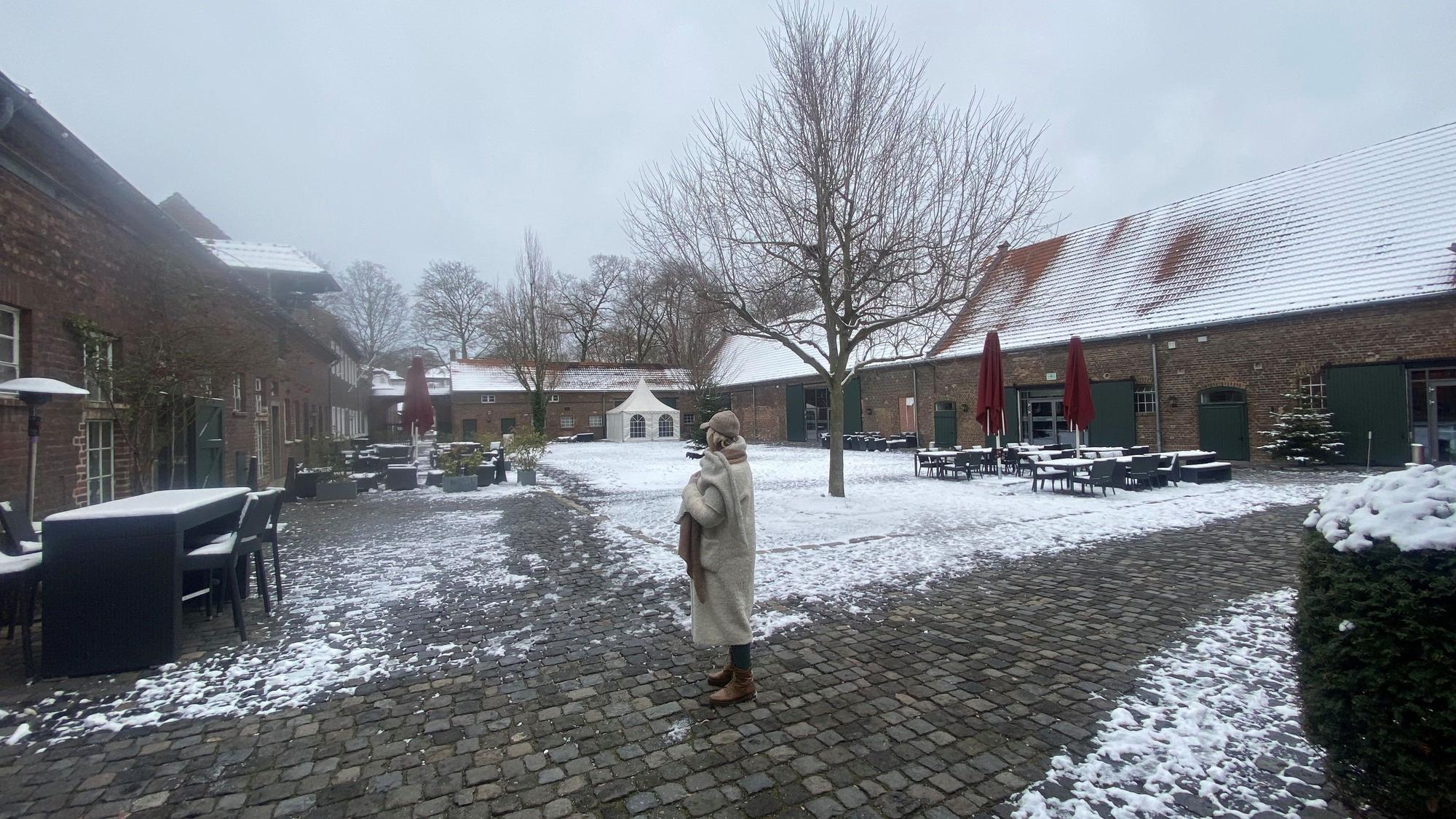 Der Innenhof eines großen Gutshofs ist zu sehen.