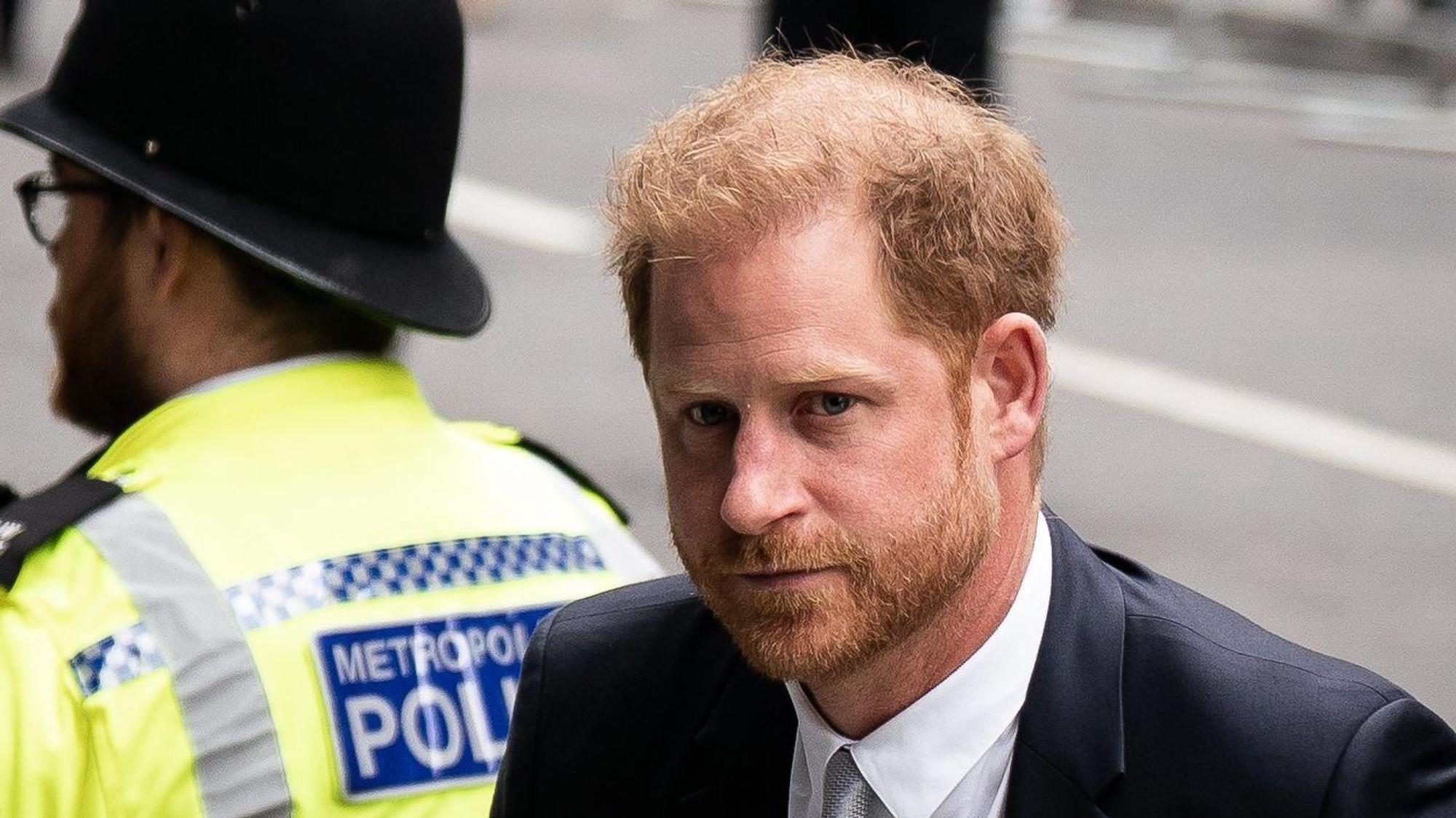 Prinz Harry, Herzog von Sussex, diente als Soldat in Afghanistan. Das macht ihn laut BKA zum Feindbild von Islamisten. Im Bild ist er im Porträt zu sehen, dahinter ein Polizist.