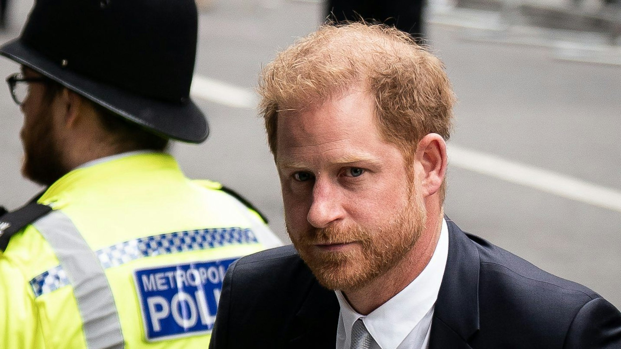 Prinz Harry, Herzog von Sussex, diente als Soldat in Afghanistan. Das macht ihn laut BKA zum Feindbild von Islamisten. Im Bild ist er im Porträt zu sehen, dahinter ein Polizist.