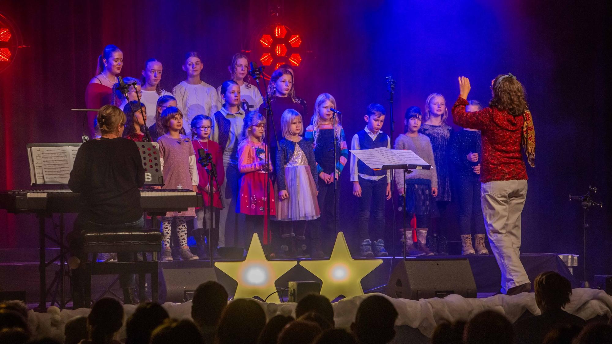 Eine Frau dirigiert einen Kinderchor.