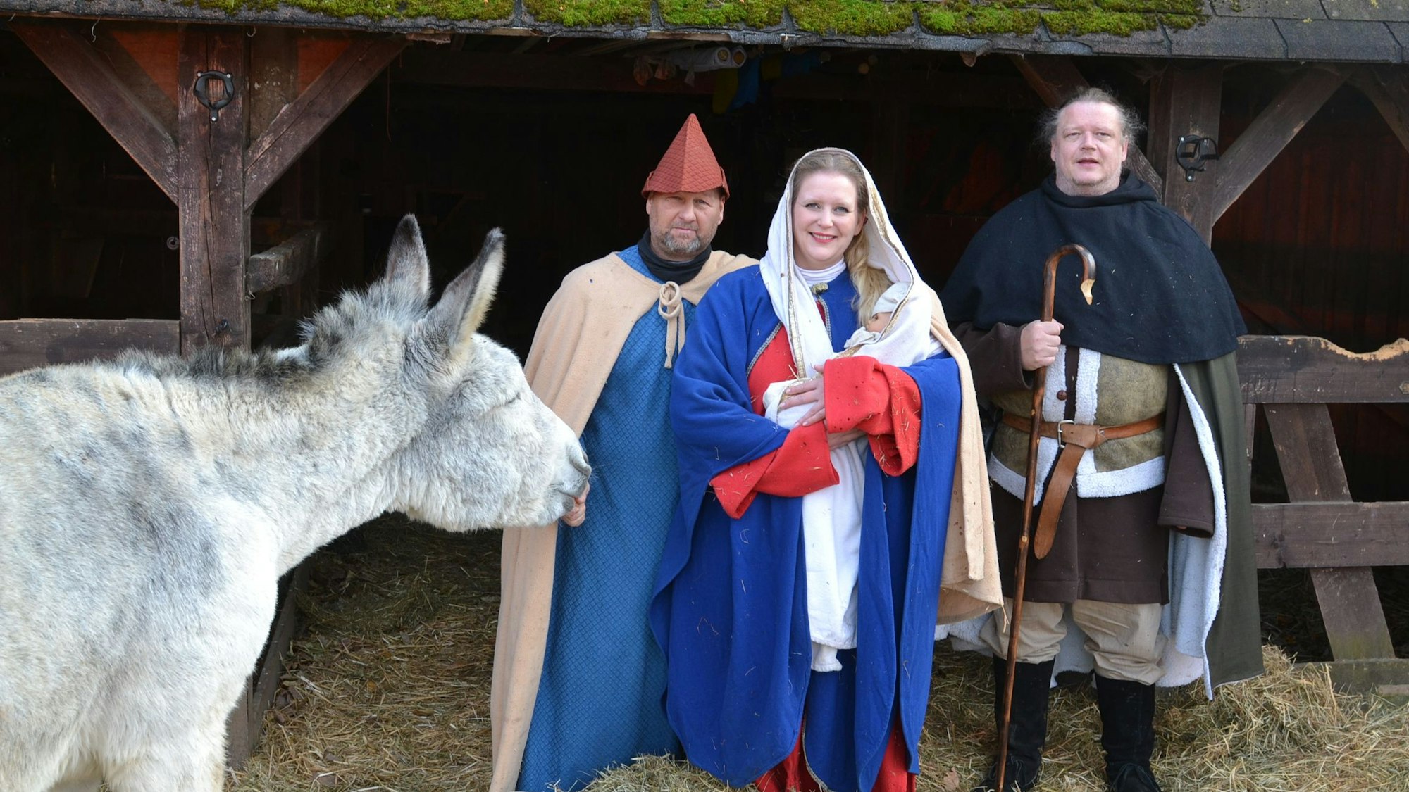 Das Bild zeigt eine Szene aus dem Krippenspiel: Maria hält das Kind im Arm.