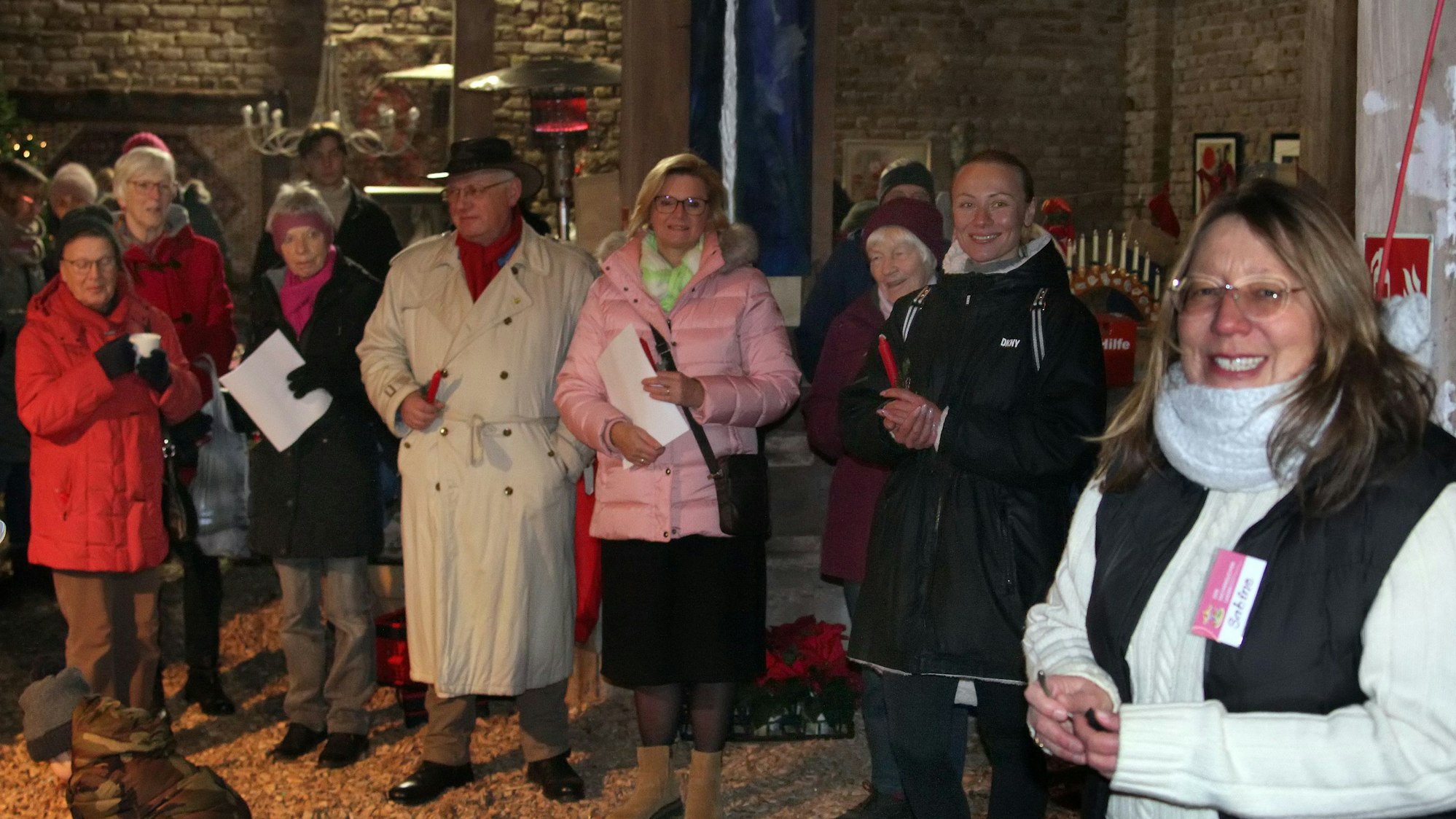 Menschen stehen in einer Scheune.