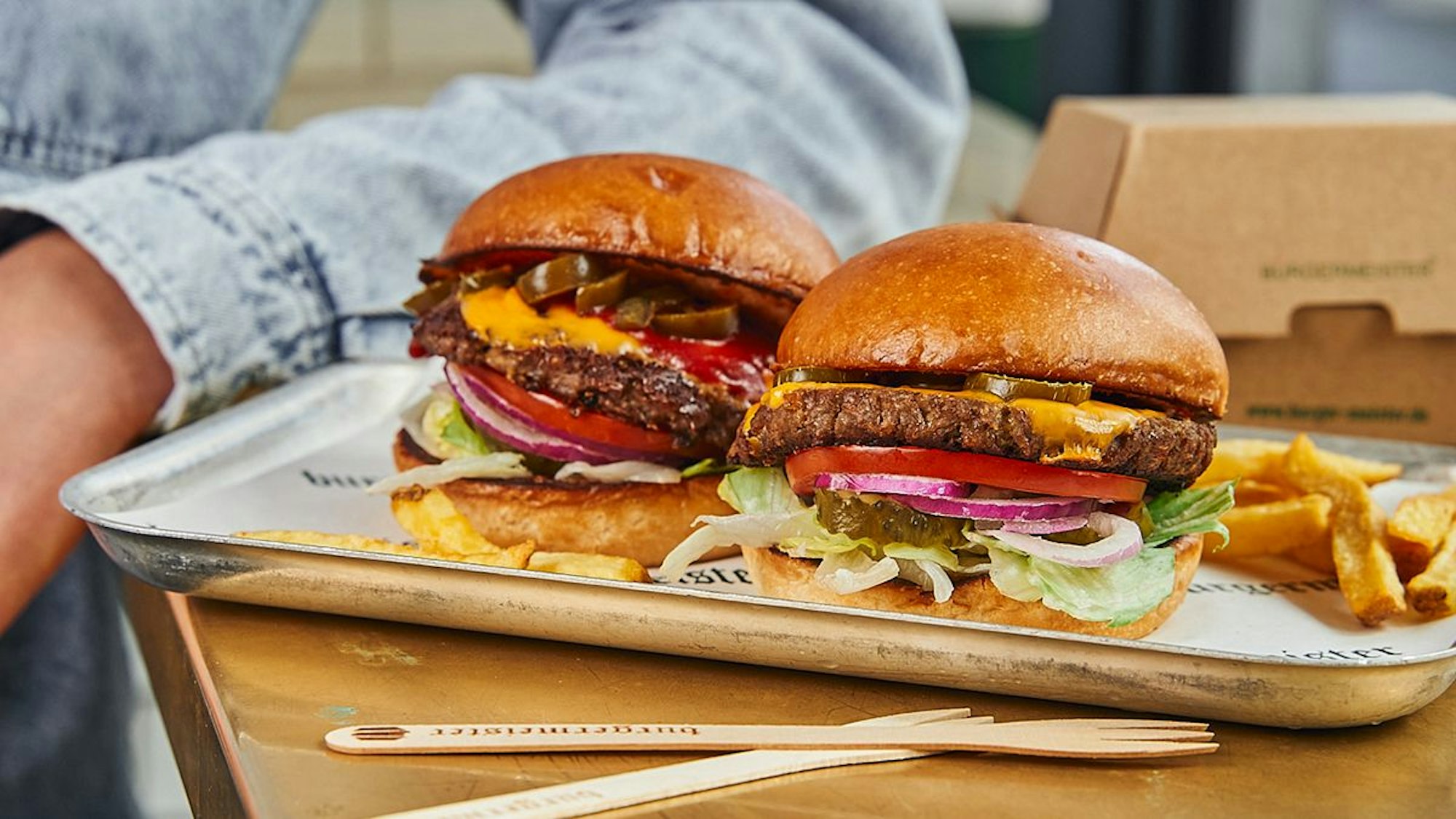 Zu sehen sind zwei Burger auf einem Teller. Köln bekommt 2024 ein neues Burger-Restaurant.
