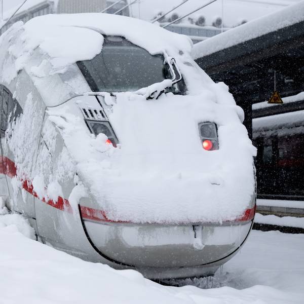 Ein ICE der Deutschen Bahn (DB) steht auf einem verschneiten Gleis am Hauptbahnhof.