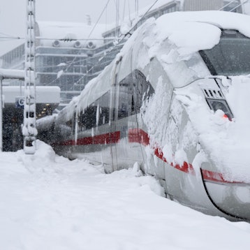 Ein ICE der Deutschen Bahn (DB) steht auf einem verschneiten Gleis am Hauptbahnhof.