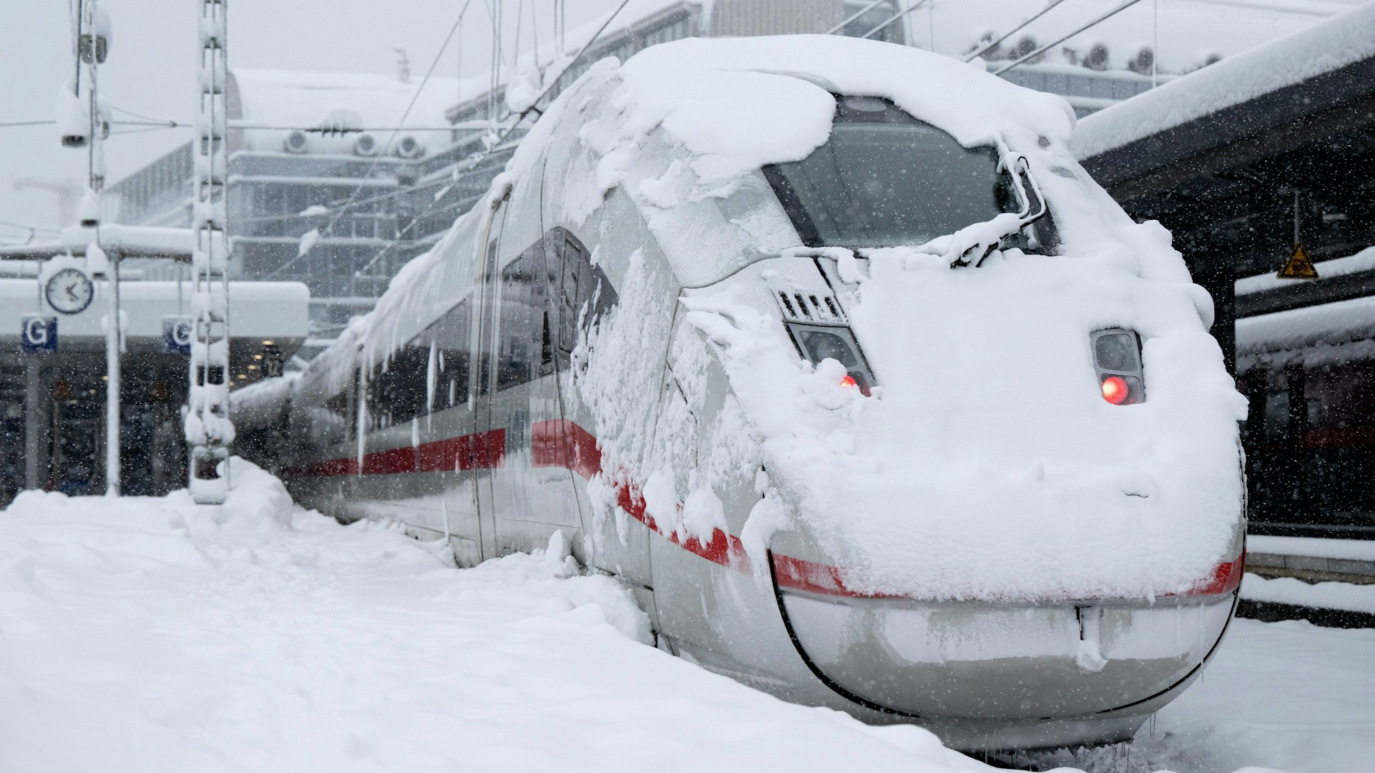 Ein ICE der Deutschen Bahn (DB) steht auf einem verschneiten Gleis am Hauptbahnhof.