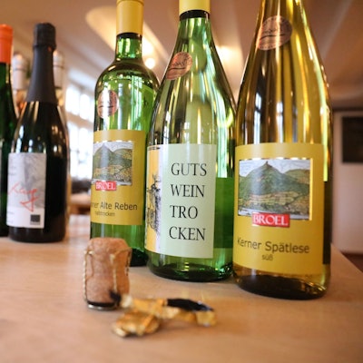 Weinflaschen stehen aufgereiht auf einem Tisch.