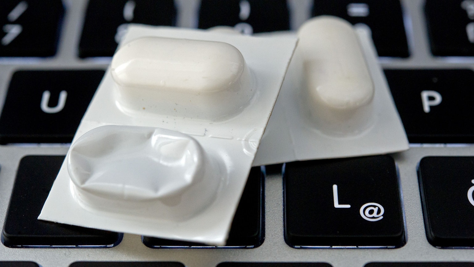 Blister mit Tabletten liegen auf einer Tastatur