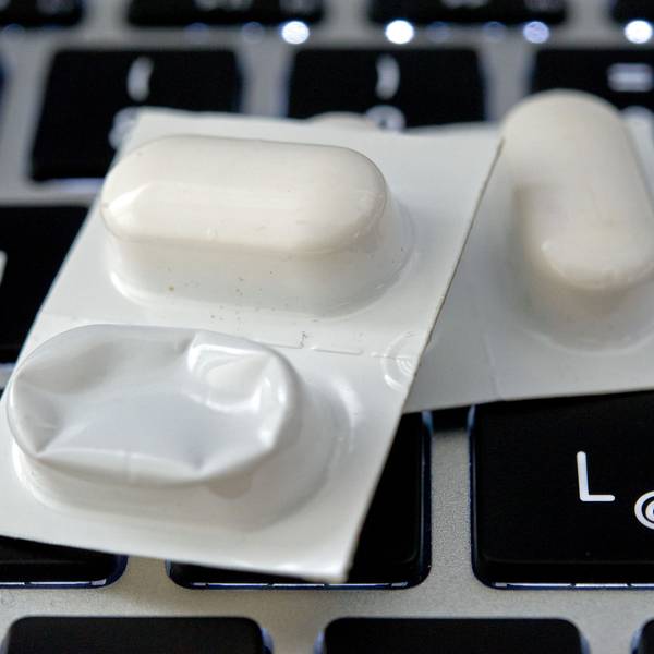 Blister mit Tabletten liegen auf einer Tastatur