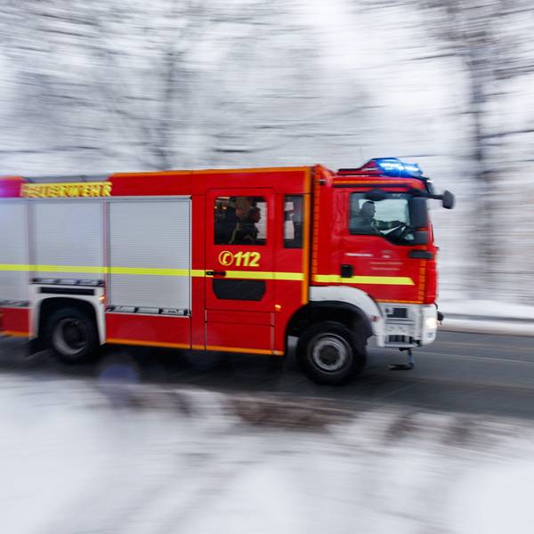 Feuerwehrfahrzeug auf verschneiter Straße.