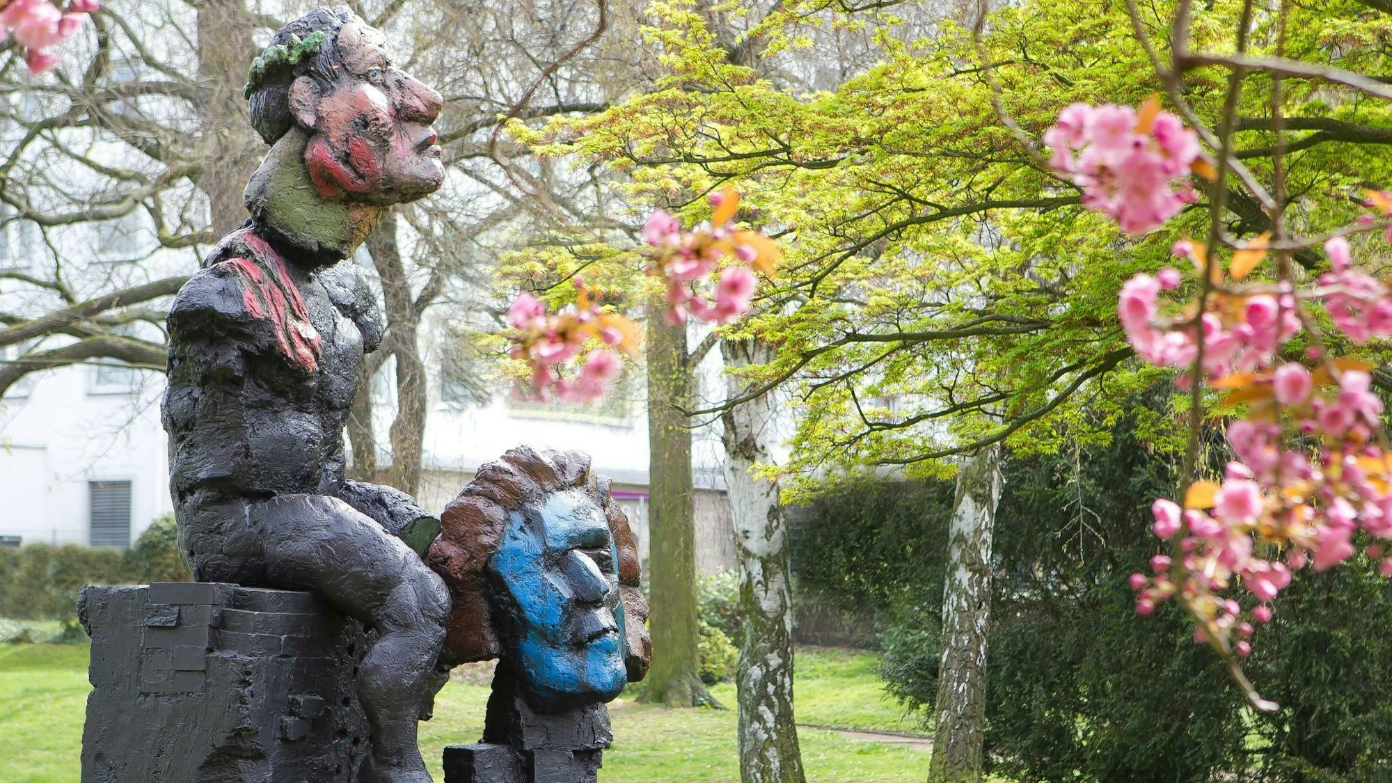 Eine Skulptur zeigt einen sitzenden Mann. Zu seinen Füßen steht ein Kopf.