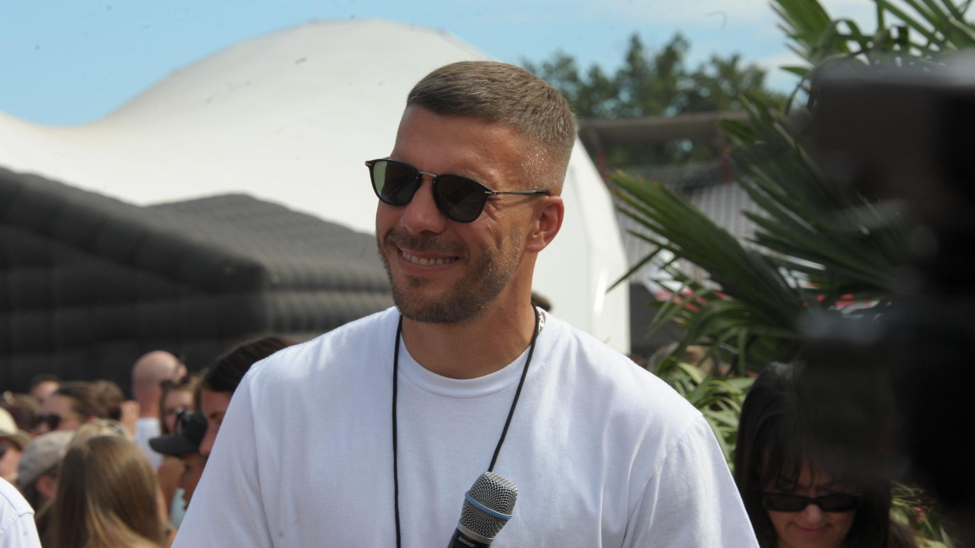 Mitorganisator Lukas Podolski lächelt auf dem Glücksgefühle-Festival.