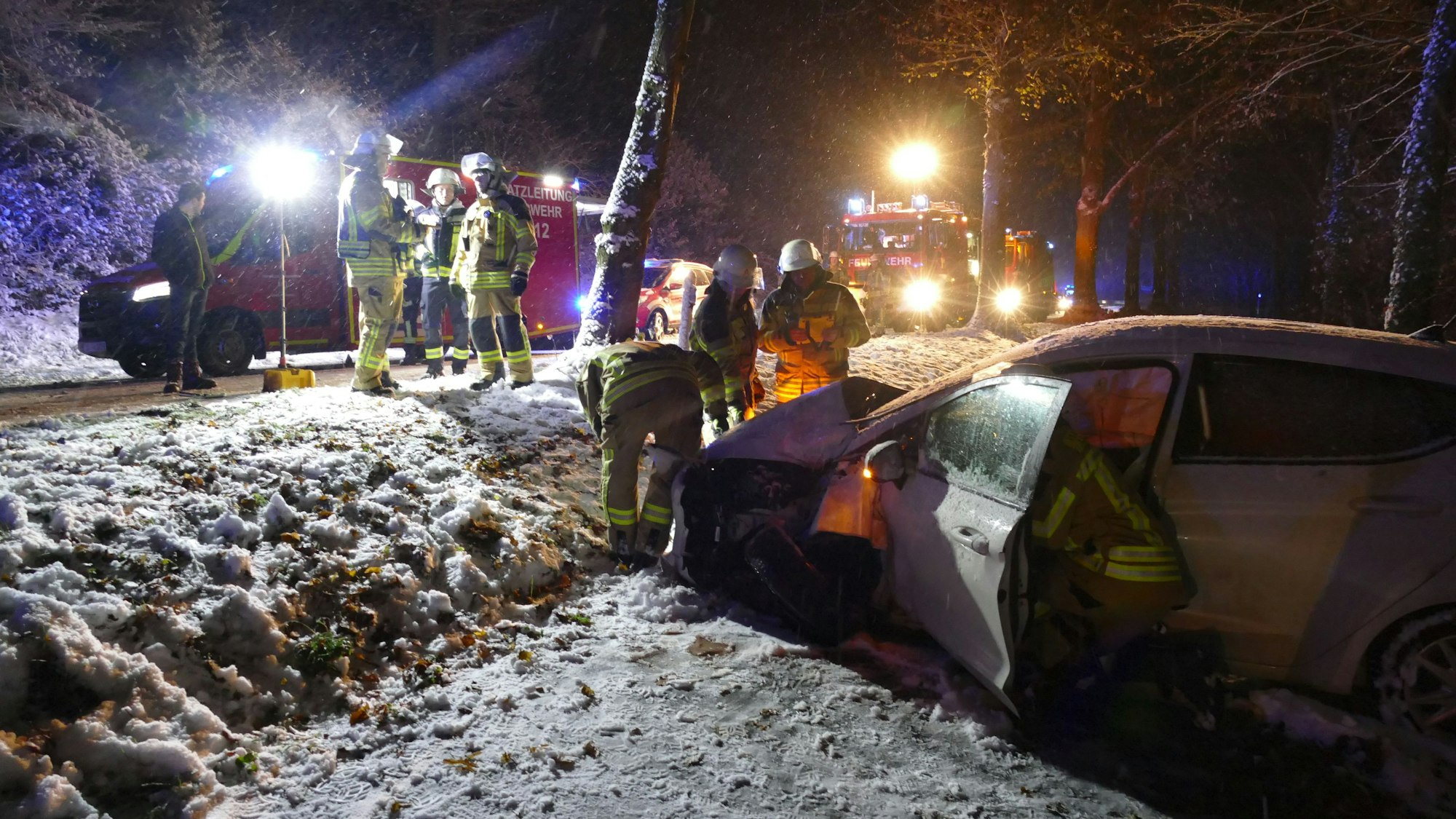 Feuerwehrleute sind im Schnee im Einsatz.
