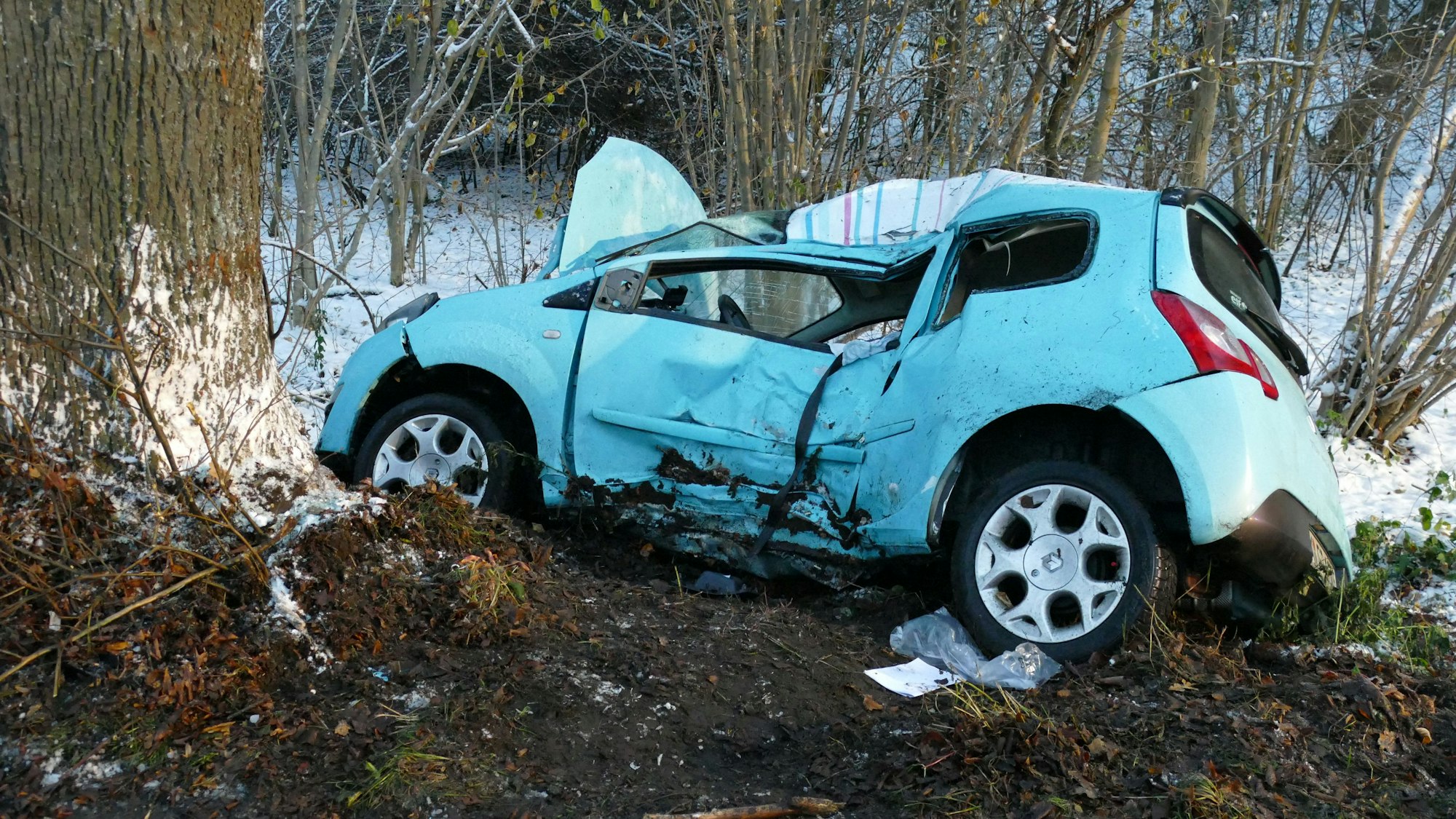 Ein schwer beschädigtes Auto liegt im Straßengraben.