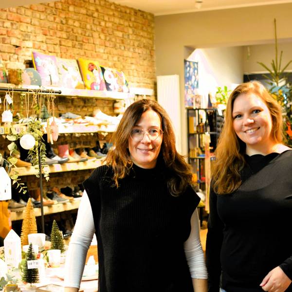 Heike Sommnitz und Lisa Schlömer stehen in einem Laden mit weihnachtlichen Deko-Artikeln und Schuhen.