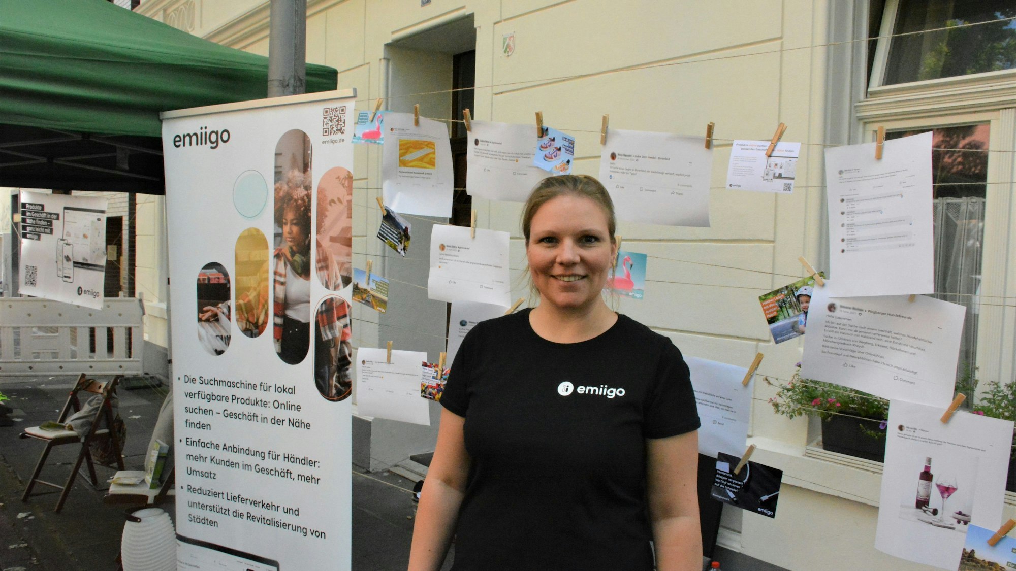 Lisa Schlömer steht vor zahlreichen Werbeplakaten und Zetteln, die an Wäscheklammern aufgehängt sind.